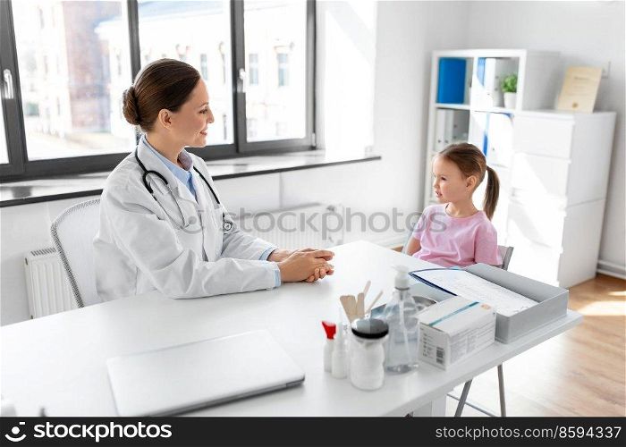 medicine, healthcare and pediatry concept - female doctor or pediatrician talking to happy smiling little girl patient on medical exam at clinic. female doctor and little girl patient at clinic