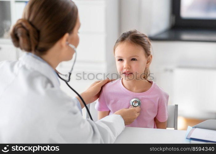 medicine, healthcare and pediatry concept - female doctor or pediatrician with stethoscope and little girl patient on medical exam at clinic. doctor with stethoscope and girl patient at clinic