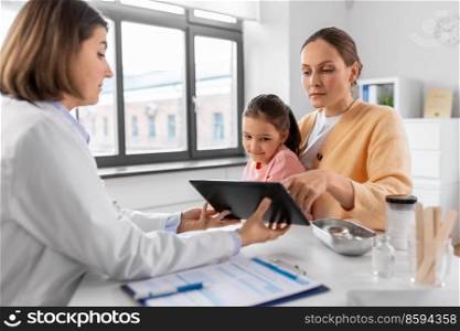 medicine, healthcare and pediatry concept - mother with little daughter and doctor showing tablet pc computer at clinic. mother, child and doctor with tablet pc at clinic