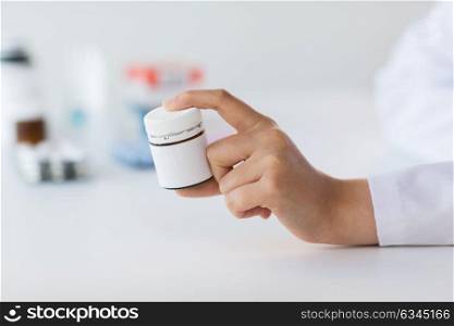 medicine, healthcare and people concept - close up of doctor hand with showing jar with drug. close up of doctor hand with medicines