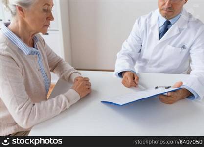 medicine, healthcare and people concept - close up of senior woman and doctor with clipboard meeting at hospital. senior woman and doctor meeting at hospital
