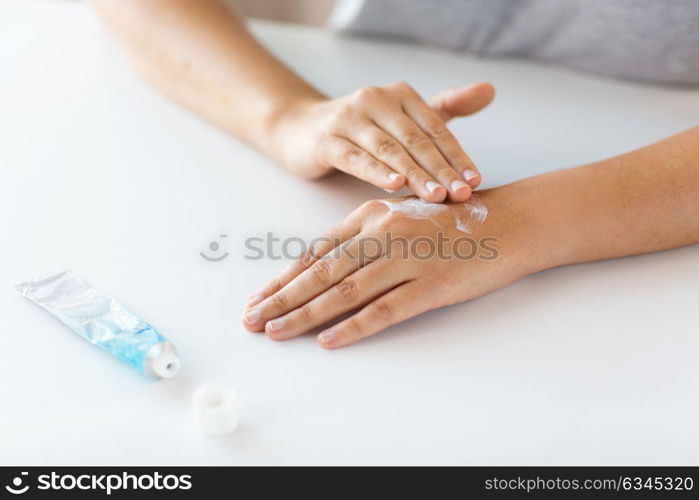 medicine, healthcare and people concept - close up of woman hands applying cream or therapeutic salve. close up of hands with cream or therapeutic salve