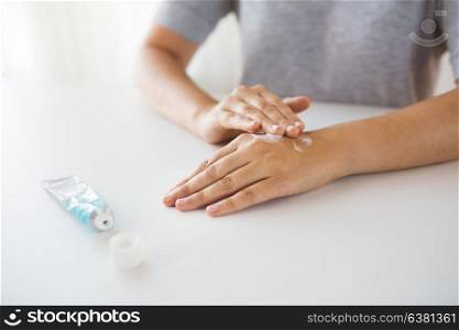 medicine, healthcare and people concept - close up of woman hands applying cream or therapeutic salve. close up of hands with cream or therapeutic salve