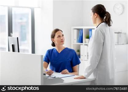 medicine, healthcare and people concept - doctor and nurse with clipboard at hospital. doctor and nurse with clipboard at hospital
