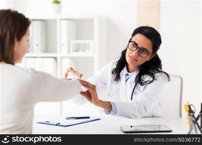 medicine, healthcare and people concept - doctor examining woman patient hand at hospital. doctor examining patient hand at hospital