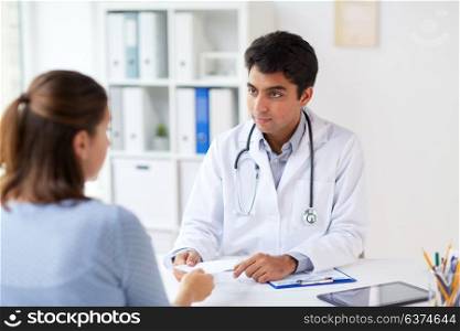 medicine, healthcare and people concept - doctor giving prescription to patient at hospital. doctor giving prescription to patient at hospital