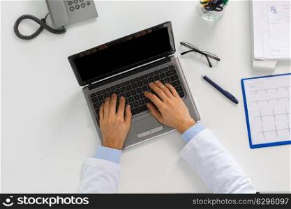 medicine, healthcare and people concept - doctor hands typing on laptop computer sitting at table in clinic. doctor hands typing on laptop at clinic