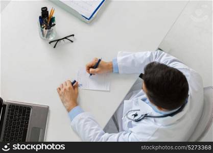 medicine, healthcare and people concept - doctor hands with prescription at table in clinic. doctor hands with prescription at clinic