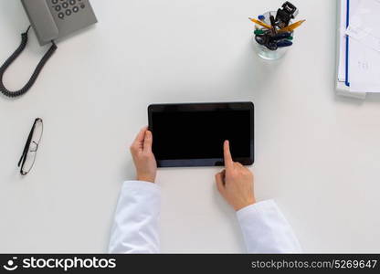 medicine, healthcare and people concept - doctor hands with tablet pc computer at table in clinic. doctor hands with tablet pc at clinic