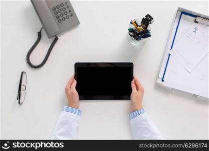 medicine, healthcare and people concept - doctor hands with tablet pc computer at table in clinic. doctor hands with tablet pc at clinic