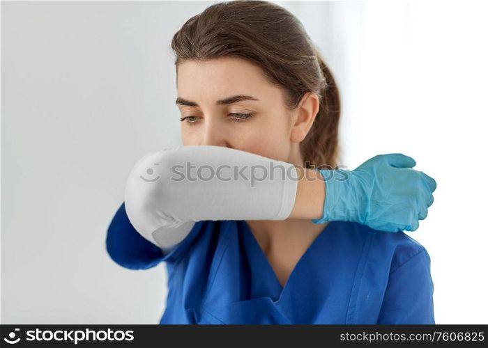 medicine, healthcare and people concept - doctor or nurse in gloves coughing covering mouth with her elbow. doctor or nurse coughing covering mouth with elbow