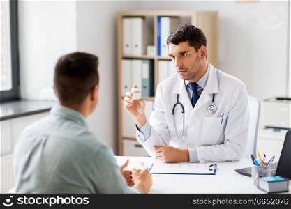 medicine, healthcare and people concept - doctor showing jar with drug to male patient at medical office in hospital. doctor showing medicine to patient at hospital