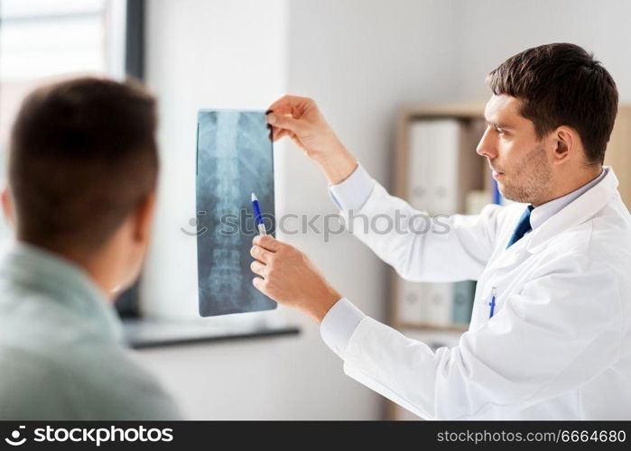 medicine, healthcare and people concept - doctor showing x-ray to patient at medical office in hospital. doctor showing x-ray to patient at hospital