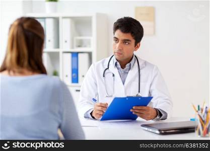 medicine, healthcare and people concept - doctor with clipboard and patient at hospital. doctor with clipboard and patient at hospital