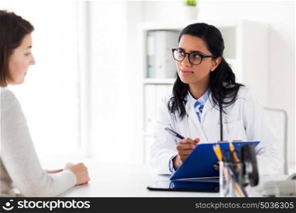 medicine, healthcare and people concept - doctor with clipboard and woman patient at hospital. doctor with clipboard and woman at hospital