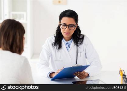 medicine, healthcare and people concept - doctor with clipboard and woman patient at hospital. doctor with clipboard and woman at hospital