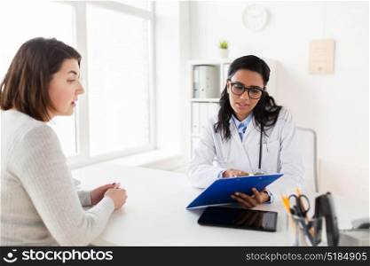 medicine, healthcare and people concept - doctor with clipboard and woman patient at hospital. doctor with clipboard and woman patient at clinic