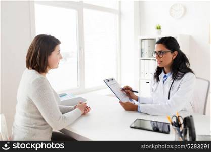 medicine, healthcare and people concept - doctor with clipboard and woman patient at hospital. doctor with clipboard and woman patient at clinic