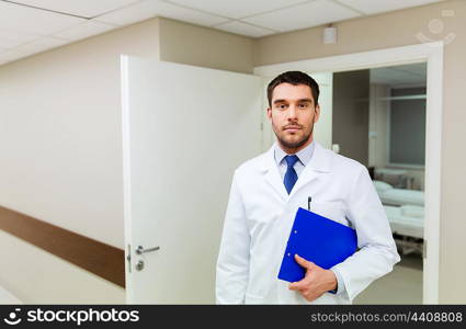 medicine, healthcare and people concept - doctor with clipboard at hospital