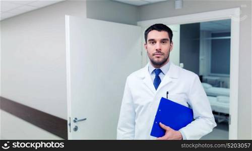 medicine, healthcare and people concept - doctor with clipboard at hospital. doctor with clipboard at hospital