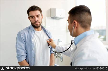 medicine, healthcare and people concept - doctor with stethoscope checking patient heart beat or breath at hospital. doctor with stethoscope and patient at hospital