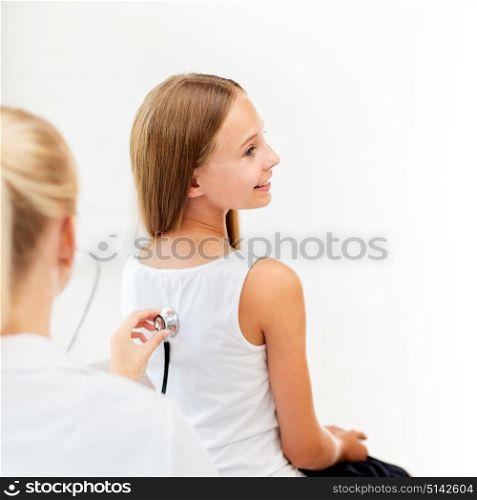 medicine, healthcare and people concept - doctor with stethoscope listening to girl heart or breath at hospital. doctor with stethoscope and girl at hospital