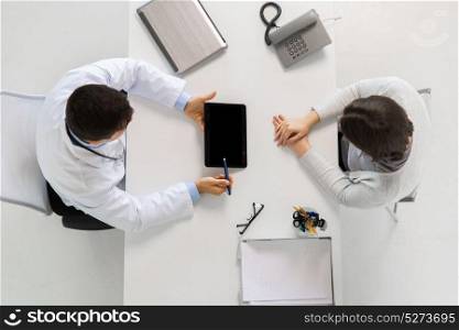 medicine, healthcare and people concept - doctor with tablet pc computer and young woman meeting at hospital. doctor and young woman meeting at hospital