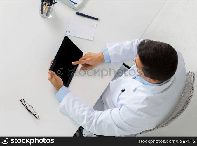 medicine, healthcare and people concept - doctor with tablet pc computer and prescription sitting at table in clinic. doctor with tablet pc and prescription at clinic