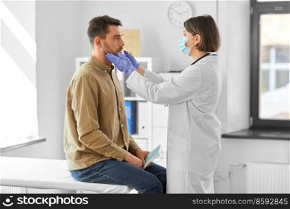 medicine, healthcare and people concept - female doctor checking lymph nodes of man patient at hospital. doctor checking lymph nodes of man at hospital