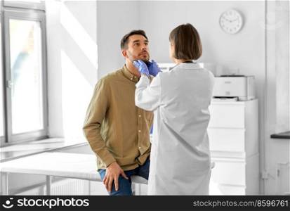 medicine, healthcare and people concept - female doctor checking lymph nodes of man patient at hospital. doctor checking lymph nodes of man at hospital