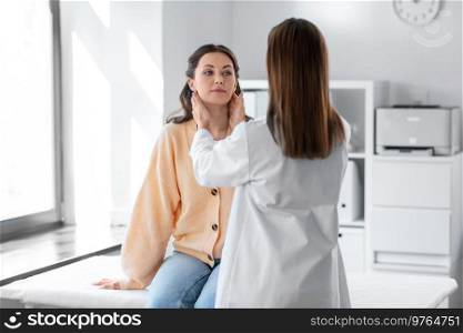 medicine, healthcare and people concept - female doctor checking lymph nodes of woman patient at hospital. doctor checking lymph nodes of woman at hospital