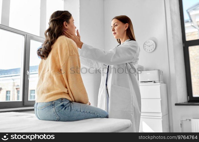 medicine, healthcare and people concept - female doctor checking lymph nodes of woman patient at hospital. doctor checking lymph nodes of woman at hospital