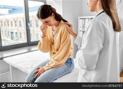 medicine, healthcare and people concept - female doctor comforting to sad woman patient at hospital. female doctor comforting sad woman at hospital