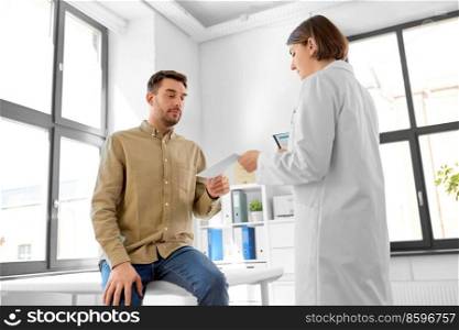 medicine, healthcare and people concept - female doctor giving prescription to man patient at hospital. doctor giving prescription to patient at hospital