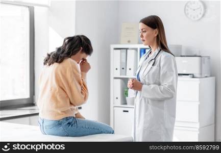 medicine, healthcare and people concept - female doctor talking to sad woman patient at hospital. female doctor talking to sad woman at hospital