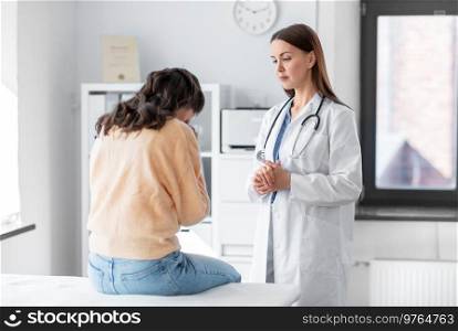 medicine, healthcare and people concept - female doctor talking to sad woman patient at hospital. female doctor talking to sad woman at hospital