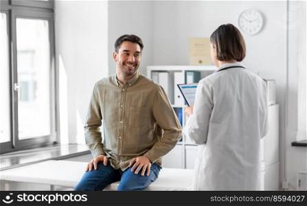 medicine, healthcare and people concept - female doctor with clipboard and happy smiling man patient meeting at hospital. doctor and smiling man meeting at hospital