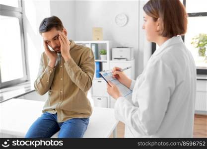 medicine, healthcare and people concept - female doctor with clipboard and male patient having health problem at hospital. doctor and man with health problem at hospital