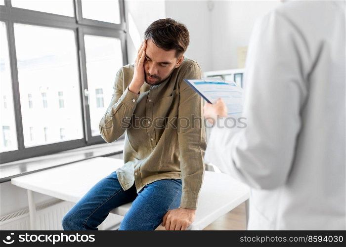 medicine, healthcare and people concept - female doctor with clipboard and sad male patient having health problem at hospital. doctor and sad man with health problem at hospital