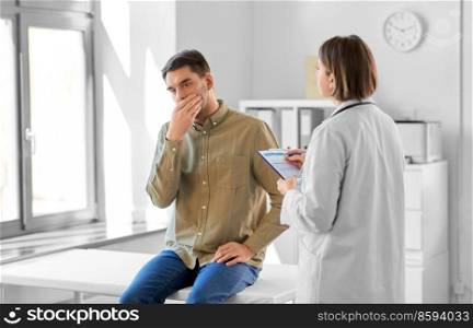 medicine, healthcare and people concept - female doctor with clipboard talking to scared or coughing man patient at hospital. female doctor and coughing man at hospital
