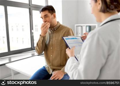medicine, healthcare and people concept - female doctor with clipboard talking to scared or coughing man patient at hospital. female doctor and coughing man at hospital