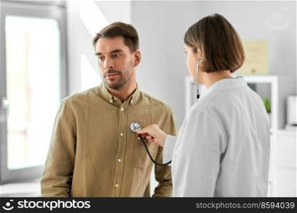 medicine, healthcare and people concept - female doctor with stethoscope and man patient at hospital. doctor with stethoscope and man at hospital