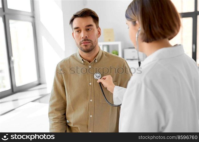 medicine, healthcare and people concept - female doctor with stethoscope and man patient at hospital. doctor with stethoscope and man at hospital