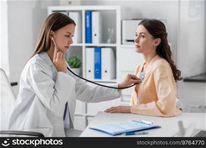 medicine, healthcare and people concept - female doctor with stethoscope and woman patient at hospital. doctor with stethoscope and woman at hospital