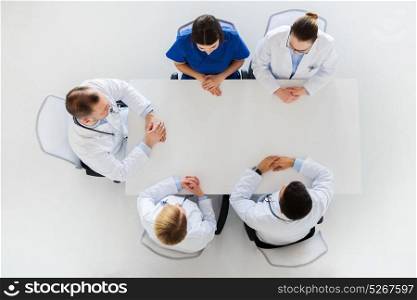 medicine, healthcare and people concept - group of doctors sitting at empty table. group of doctors sitting at empty table