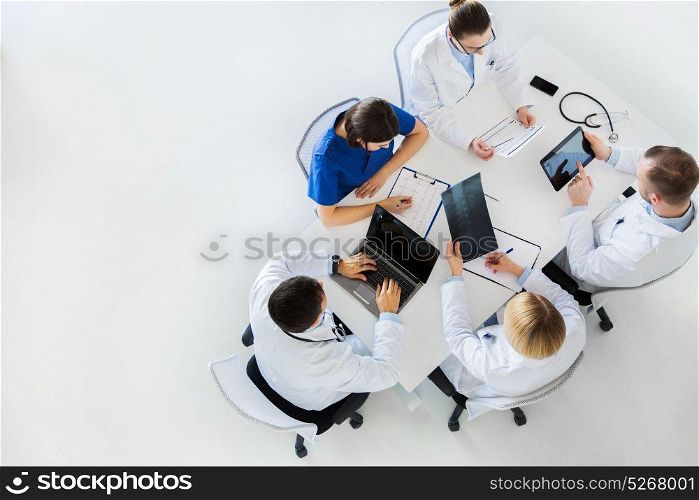 medicine, healthcare and people concept - group of doctors with x-ray, cardiogram, laptop and tablet pc computers on conference at hospital. doctors with x-ray and cardiogram at hospital