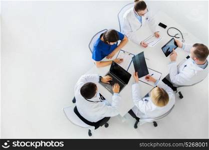 medicine, healthcare and people concept - group of doctors with x-ray, cardiogram, laptop and tablet pc computers on conference at hospital. doctors with x-ray and cardiogram at hospital