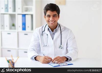 medicine, healthcare and people concept - happy male doctor with stethoscope and clipboard at clinic. happy doctor with clipboard at clinic