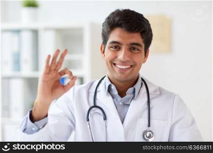 medicine, healthcare and people concept - happy male doctor with stethoscope at clinic showing ok hand sign. happy doctor with stethoscope at clinic showing ok