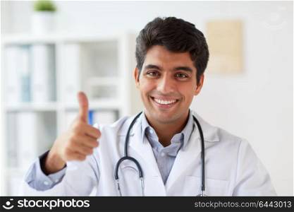 medicine, healthcare and people concept - happy male doctor with stethoscope at clinic showing thumbs up. happy doctor at clinic showing thumbs up
